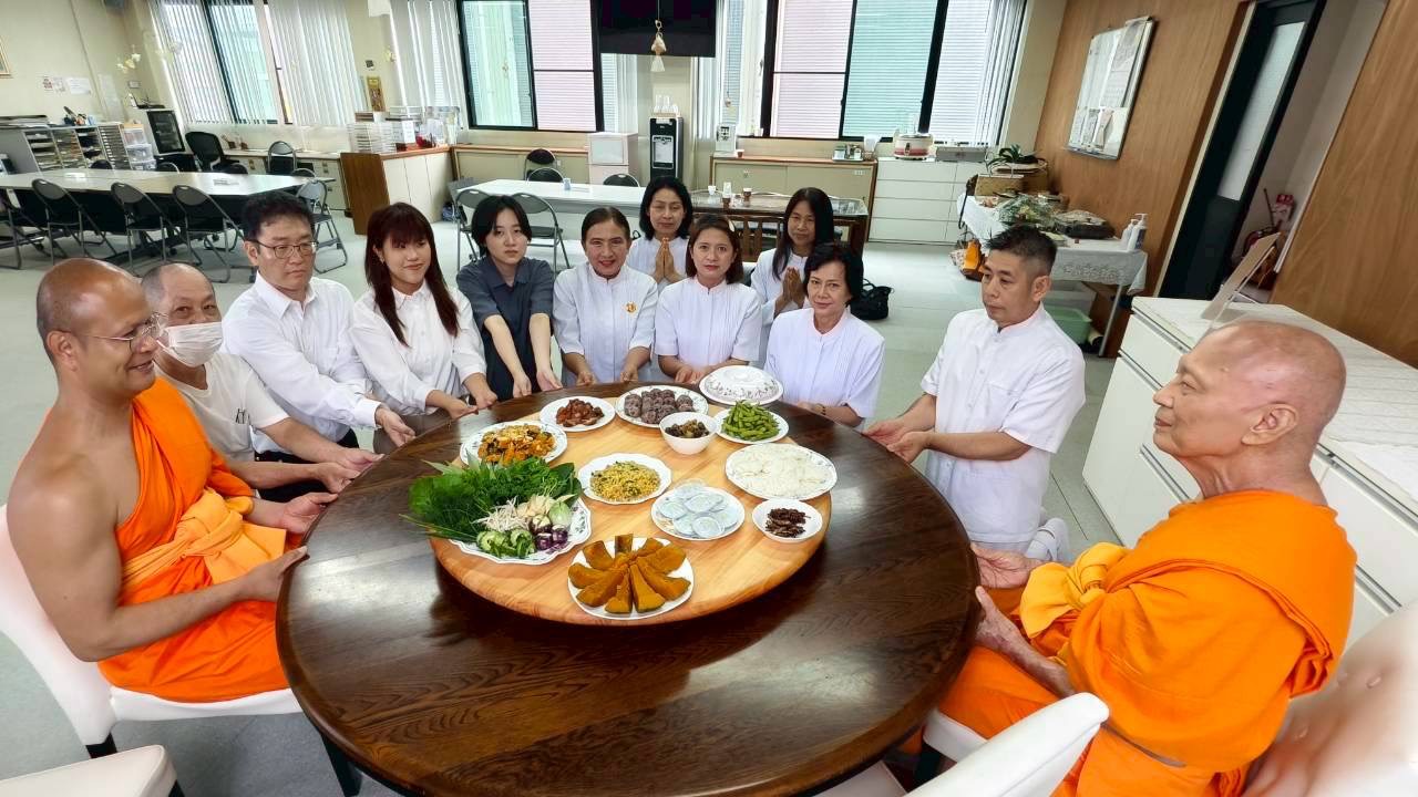 信者と共に僧侶に食事を献上している様子