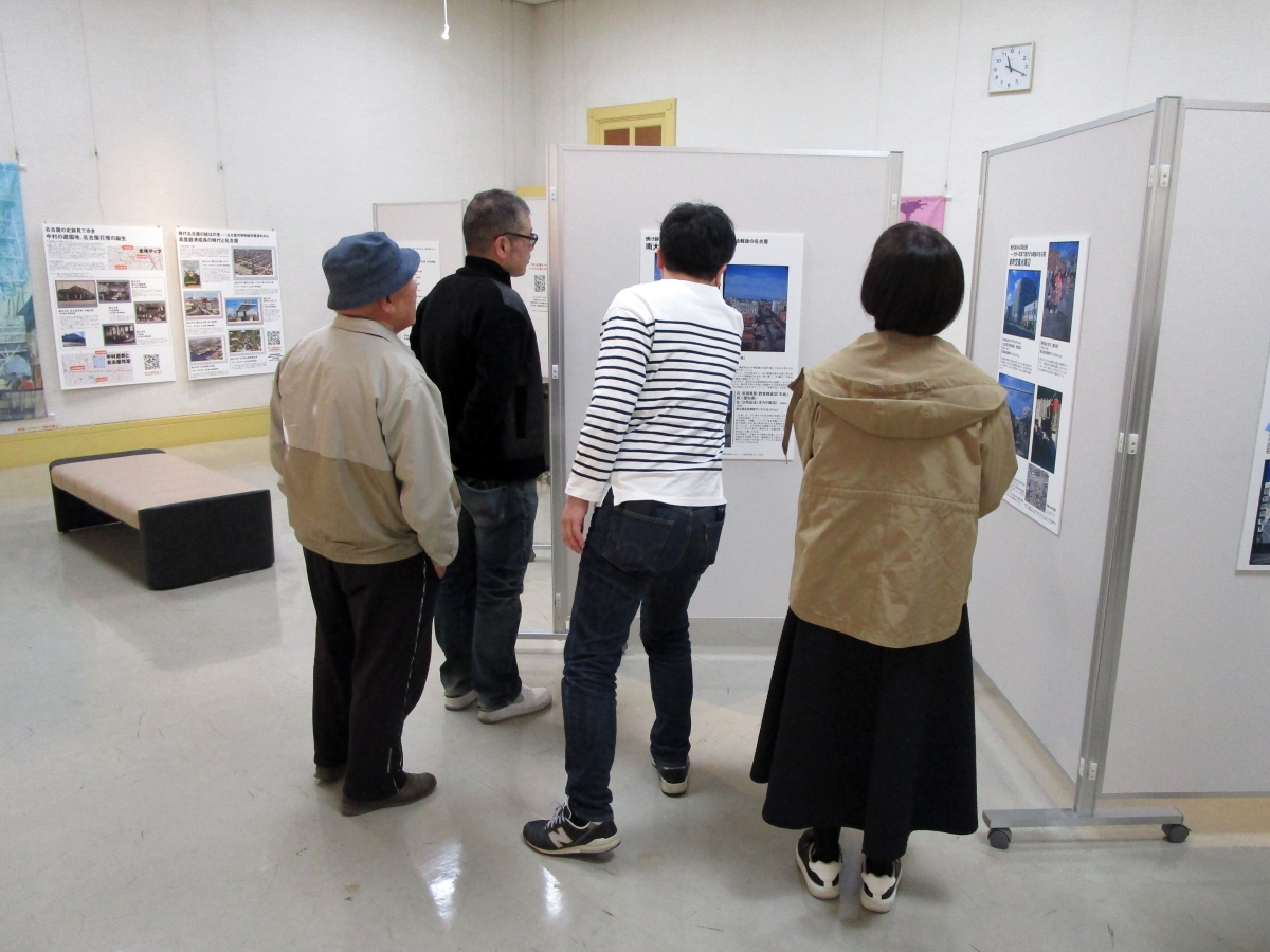 訪れた市民に展示を案内する佐藤准教授