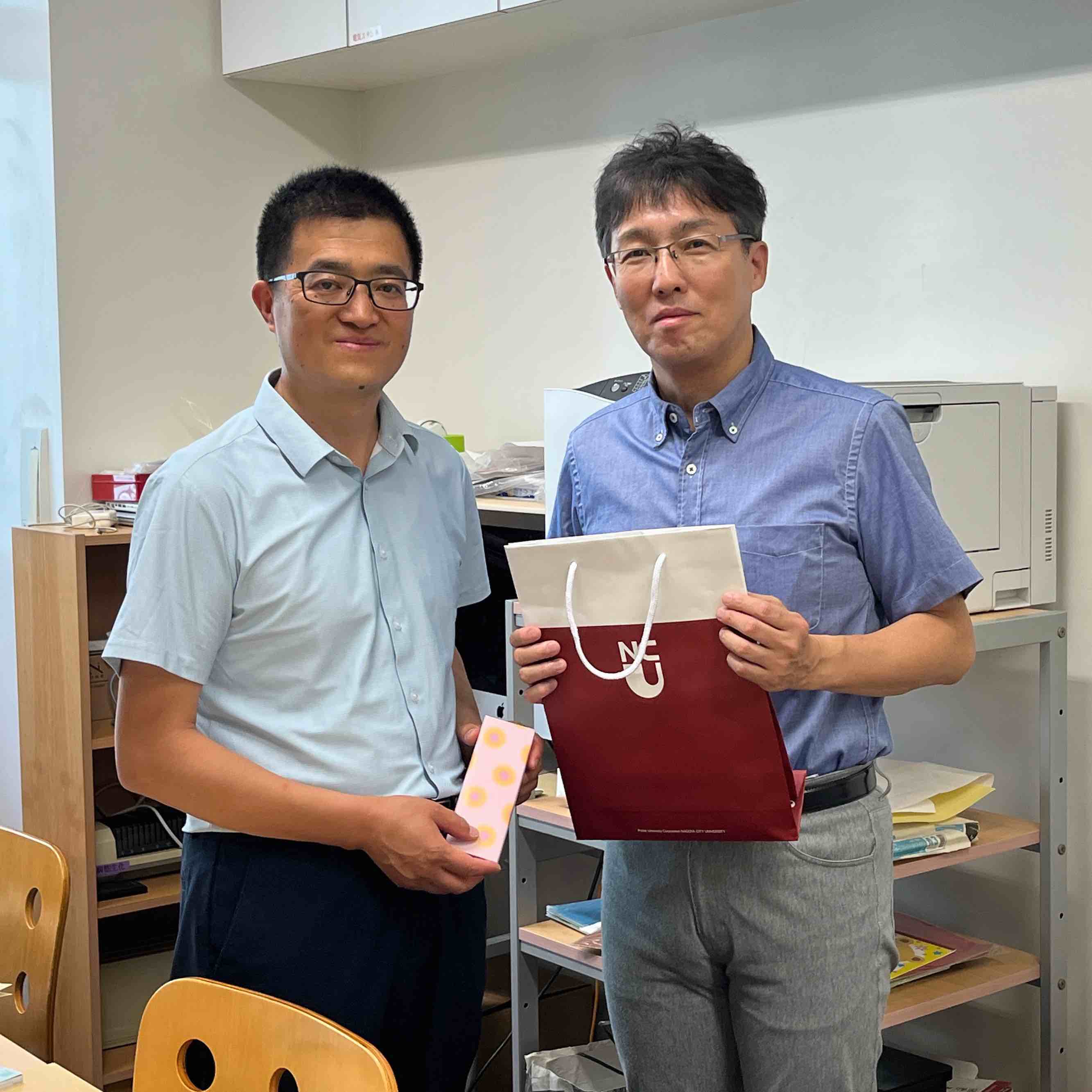 Prof. Yang, Lanzhou, and our dean exchange gifts.